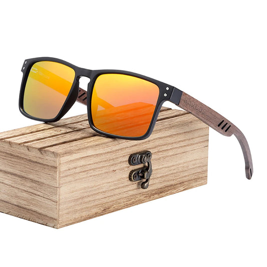 Sunglasses with orange lenses and black frames on a wooden box, featuring the BARCUR brand.